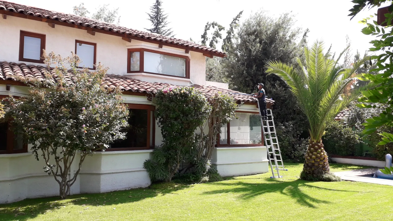 Técnico trabajando en el techo de tejas de una casa en la Región Metropolitana
