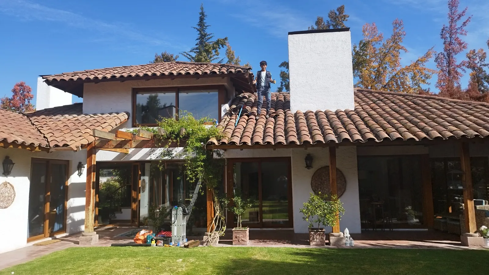Técnico inspeccionando el techo de tejas de una vivienda para coordinar un servicio en Santiago