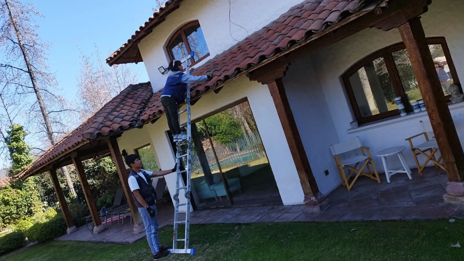 Técnicos realizando mantención de un techo de tejas en una casa de la Región Metropolitana