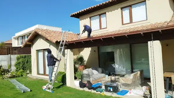 Casa en Chicureo con techo de teja chilena en proceso de reparación y ajuste